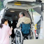 車いすのお祖父さんがリフトで車に乗っている所